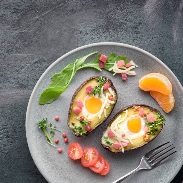 istock Keto diet dish: Avocado boats with ham cubes, quail eggs, cheese on dark with copy-space 1166666447