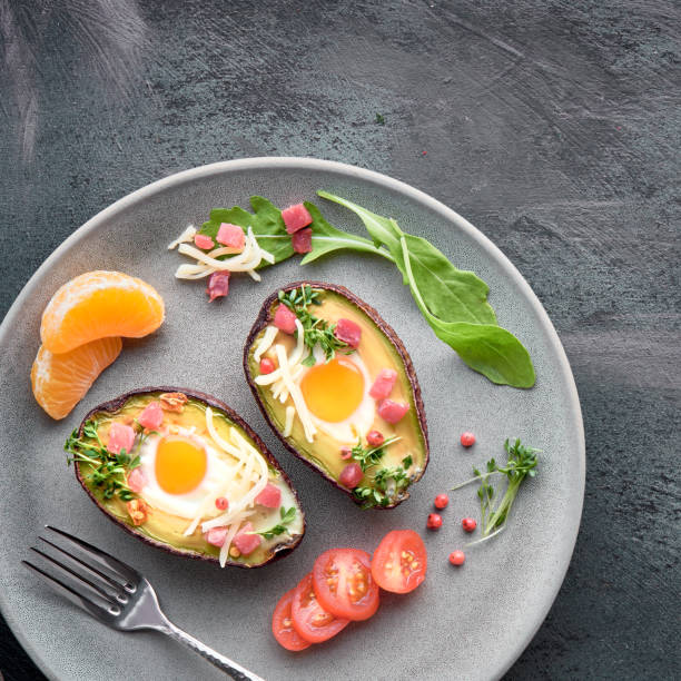 istock Keto diet dish: Avocado boats with ham cubes, quail eggs, cheese on dark with copy-space 1166667021