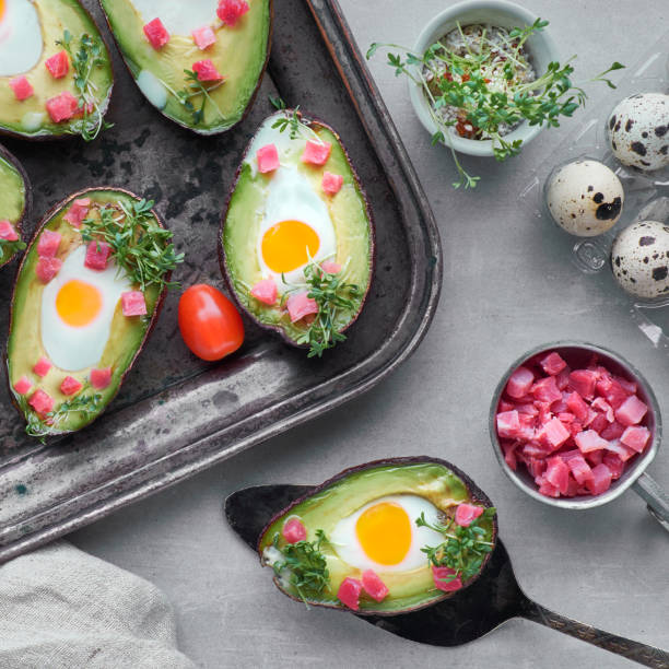 istock Keto diet dish: Avocado boats with ham cubes, quail eggs, cheese on dark with copy-space 1166667134