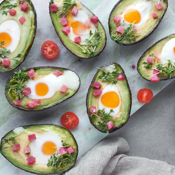 istock Keto diet dish: Avocado boats with ham cubes, quail eggs, cheese on dark with copy-space 1166667246
