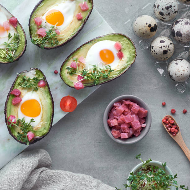 istock Keto diet dish: Avocado boats with ham cubes, quail eggs, cheese on dark with copy-space 1166667343