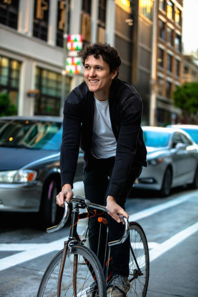 istock Smiling Young Man Riding in Protected Bike Lane 1166670984