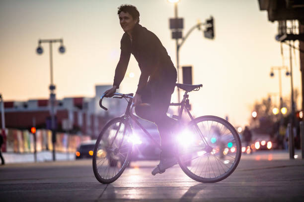 istock Car Headlights Partially Silhouetting Cyclist 1166671045