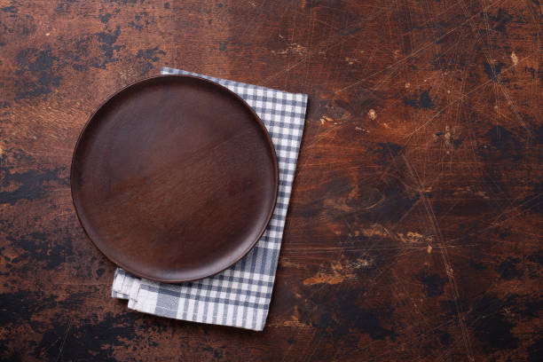 Wooden table with empty plate and linen napkin Copy space stock photo