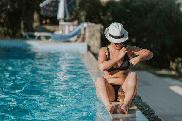 istock Beautiful young  woman by the pool 1166675561