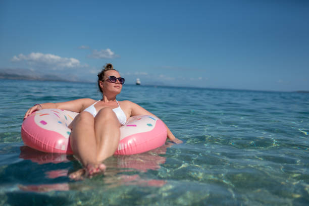 istock Beautiful young woman with pink donut circle 1166675768
