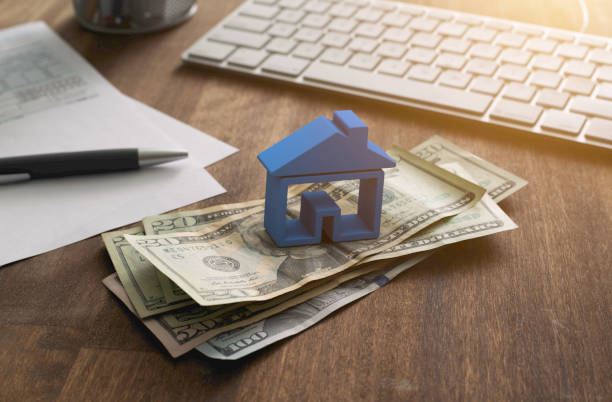 Home Finance Mortgage and Taxes Deduction 3D house on pile of money with tax and financial forms on the desk. tax form photos stock pictures, royalty-free photos & images