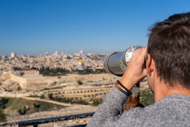 istock Man watching the Old City of Jerusalem with a binocular 1166684203