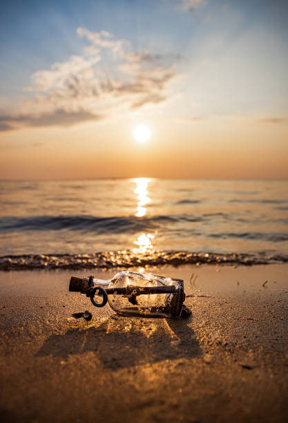 istock Message in the bottle against the Sun setting down 1166685250