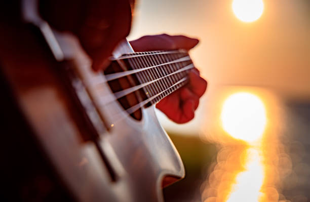 istock Woman at sunset playing the ukulele 1166685308