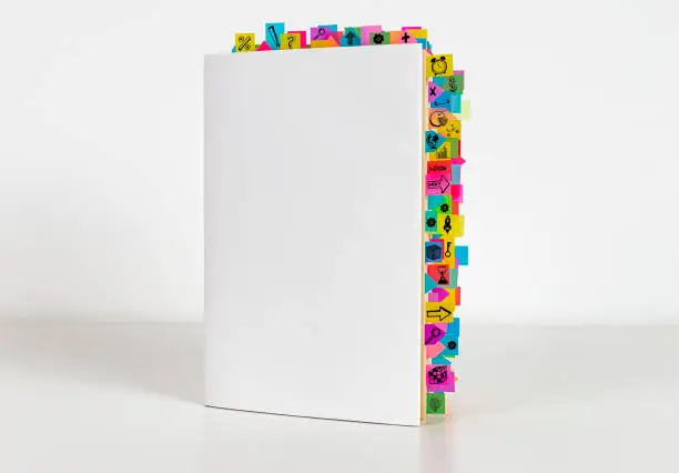 Business book and sticky reminders on the white background.