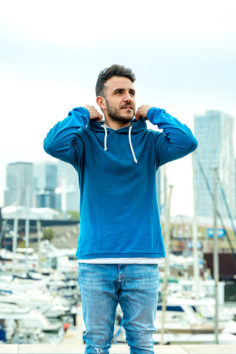 Casual young man with Barcelona skyline at background, taken from the port.