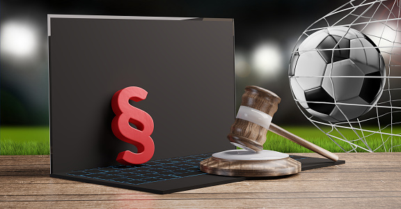red paragraph and judge gavel on a computer in front of a soccer stadium background 3d-illustration