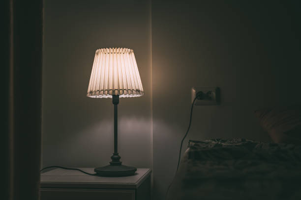 istock Bedroom lamp on night table in hotel room at night 1166691440