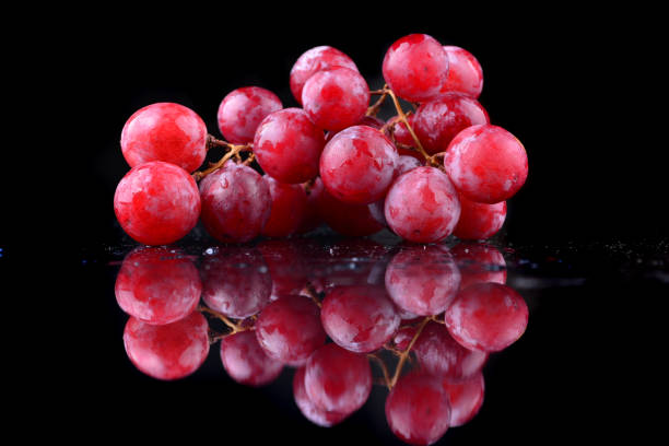 istock bunch of red grapes isolated on black background 1166693488