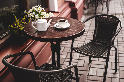 Street view of a summer terrace cafe with table and chairs.
