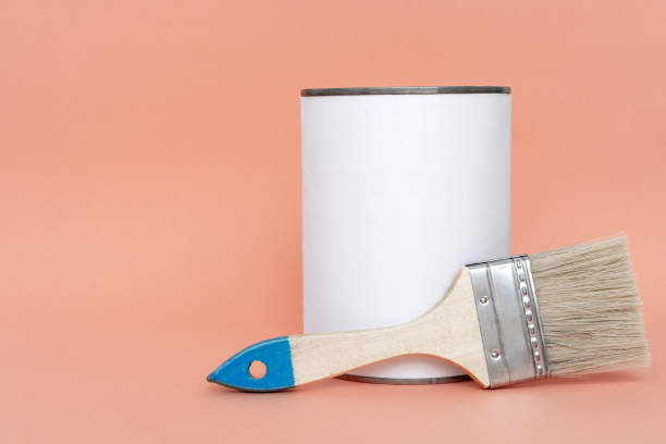 istock Brush with wooden handle on open cans on orange pastel background. Renovation concept. Place for text. 1166698774