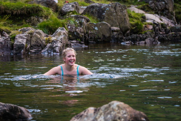 wild swimming woman in clear mountain stream lake district cumbria - common women teenage girls exercising imagens e fotografias de stock