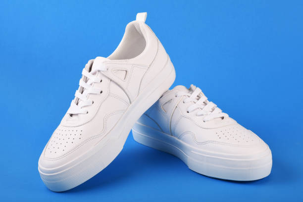 istock A pair of white sneakers on the blue background 1166702344