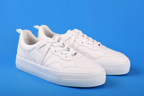 istock A pair of white sneakers on the blue background 1166702416
