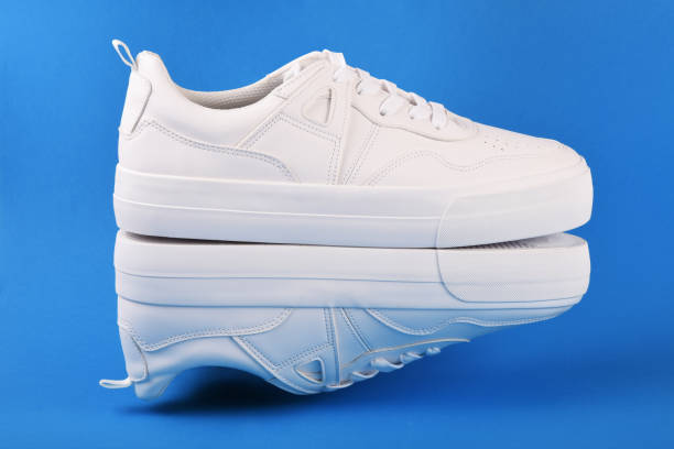 istock A pair of white sneakers on the blue background 1166702986