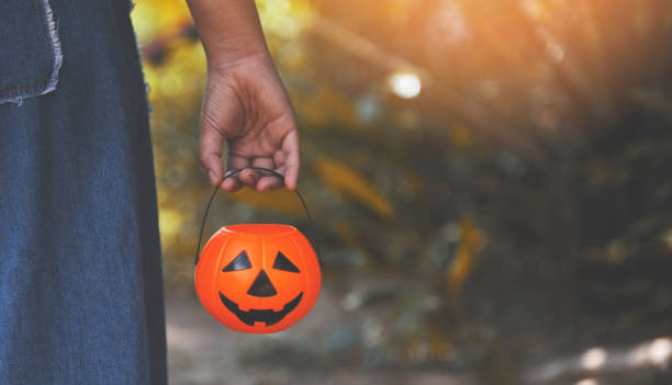 istock Halloween pumpkin lantern on hand / head jack o lantern evil funny faces holiday decoration on halloween nature 1166709660