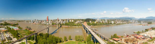 Surrey, Vancouver Aerial panoramic view of Pattullo Bridge and Skytrain Bridge over the Fraser River. Taken in Surrey, Greater Vancouver, British Columbia, Canada. new westminster stock pictures, royalty-free photos & images