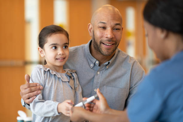 istock Father Holding Young Daughter At A Doctors Appointment 1166714833