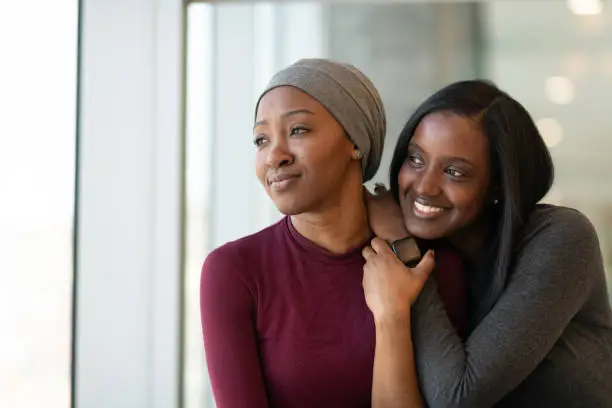 Photo of Young African American woman with cancer spends time with a friend.