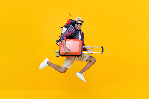 Emocionado feliz joven asiático turista con equipaje saltar photo
