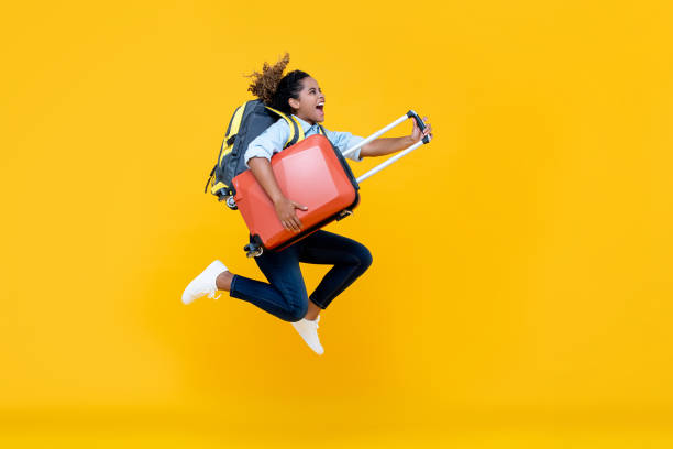 podekscytowana afroamerykanka kobieta turystyczna z plecakiem i skokiem bagażu - female mobility blank teenage girls zdjęcia i obrazy z banku zdjęć
