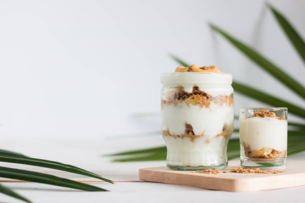 здоровая еда из гранолы в стекле, йогурте и кукурузных хлопьях украшает пищу орехом кешью - tyle стоковые фото и изображения