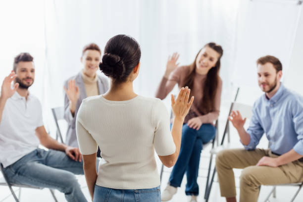istock people sitting and raising hands during group therapy session 1166725343