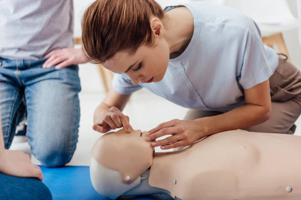 woman practicing cpr technique on dummy during first aid training woman practicing cpr technique on dummy during first aid training first aid class stock pictures, royalty-free photos & images