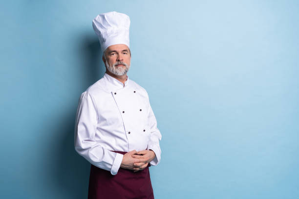 istock Attractive smiling cheerful chef isolated on blue. 1166727857