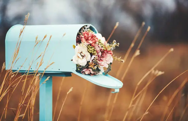 Photo of Pastel teal mailbox with bouquet of flowers