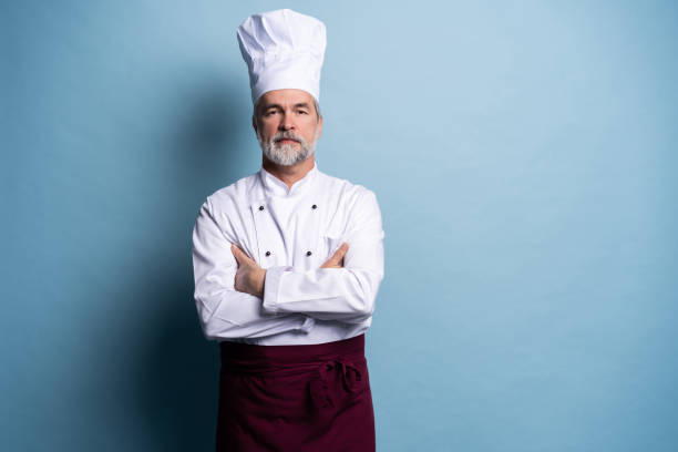 istock Attractive smiling cheerful chef isolated on blue. 1166733890