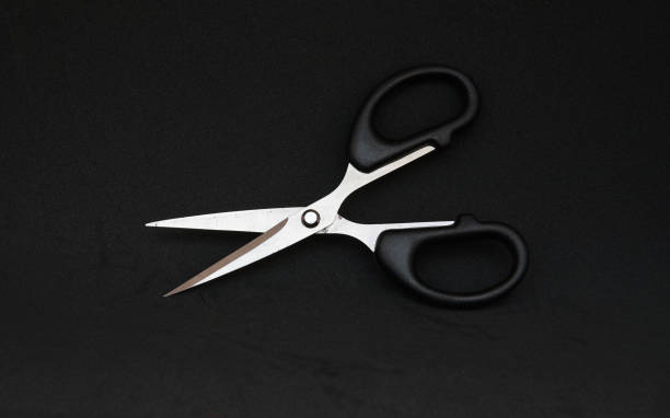 istock Black scissor in black background 1166734336