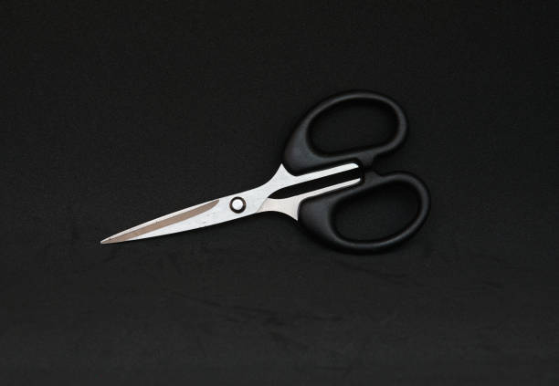 istock Black scissor in black background 1166734337