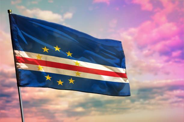 istock Fluttering Cabo Verde flag on colorful cloudy sky background. Prosperity concept. 1166734970