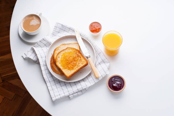 istock Morning toasts with butter and jam on white table 1166736577