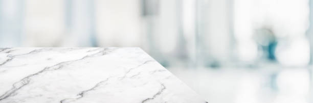 istock marble table top product display background with blur business office hallway.left perspective stone kitchen counter with people waiting doctor in hallway.Banner mockup presentation 1166737014