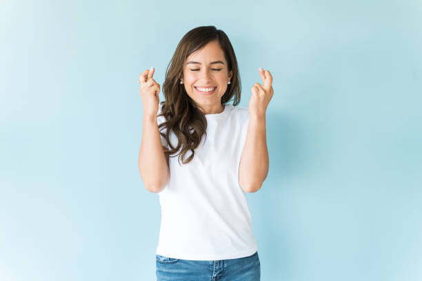 istock Smiling Female Wishing For Good Fortune In Studio 1166740639