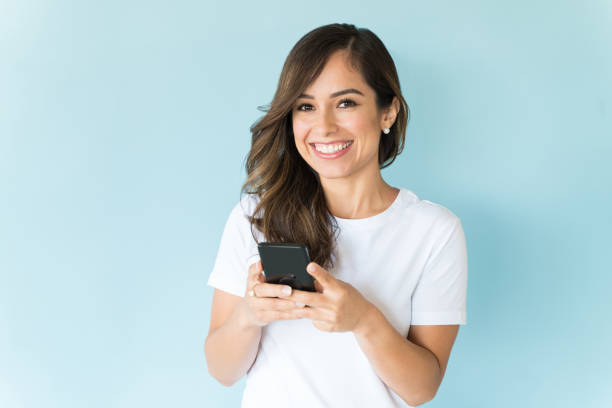 istock Happy Female Texting On Mobile Phone In Studio 1166741532