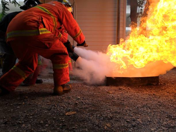 los bomberos están enseñando la extinción de incendios con extintores. - teachings fotografías e imágenes de stock