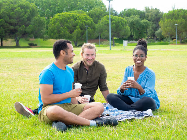 istock Happy young friends resting on grass in park 1166753466