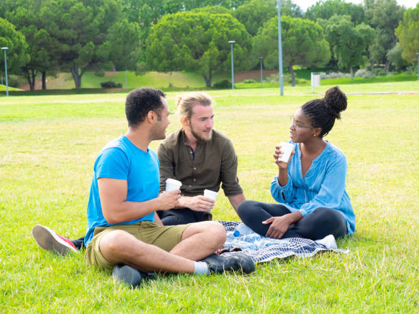 istock Multiracial friends holding paper cups in park 1166753533