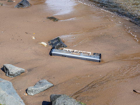New York, USA. Abandoned pianola or brought from the waters of the Hudson river on a beach of the Dumbo district. Environmental pollution. Act of vandalism. Lack of respect for the environment