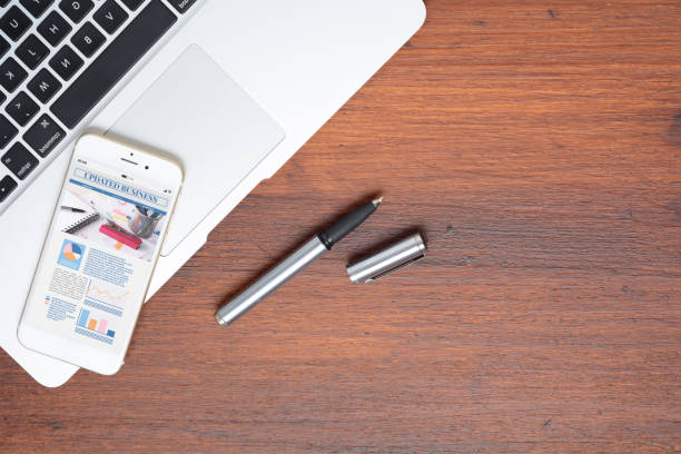 istock Office desk table and smartphone phone with graphic information about company growth 1166755301