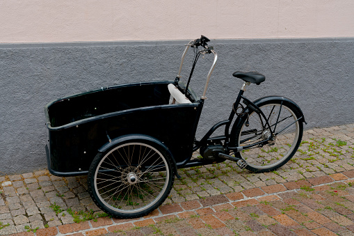 Detail view of a cool black retro electric bicycle with large cargo hold in front